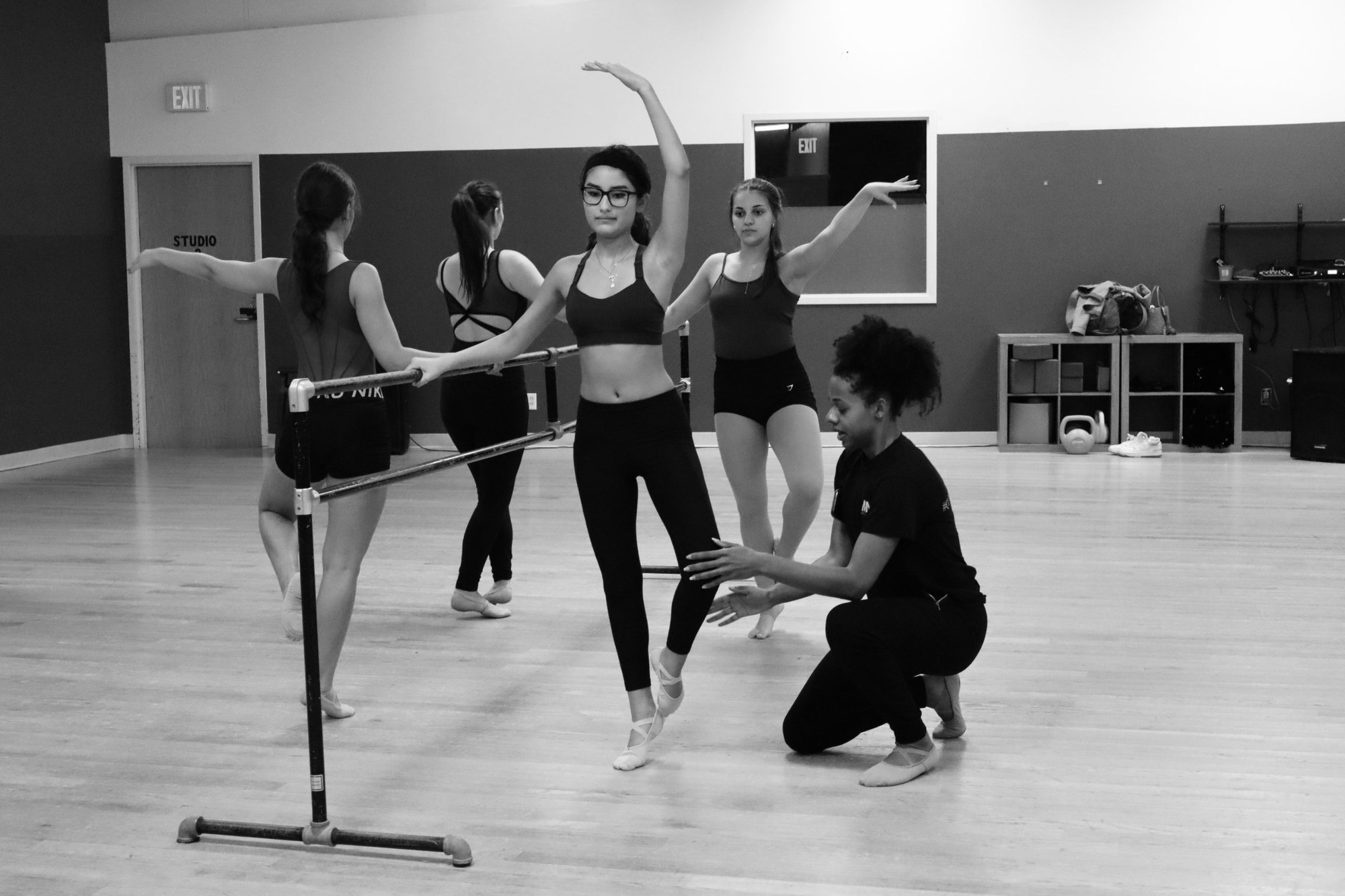 A teacher correcting a dancer at the barre